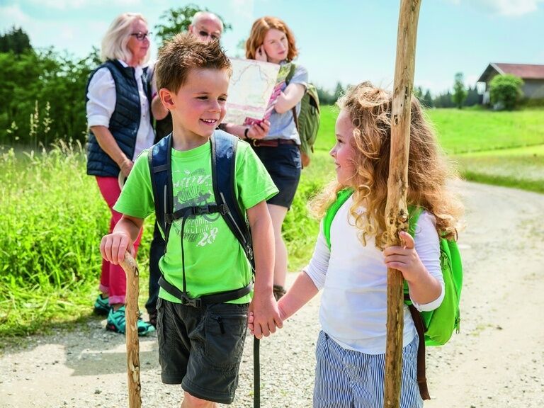 Mädchen und Junge halten Händchen bei einer Familienwanderung im Harz.