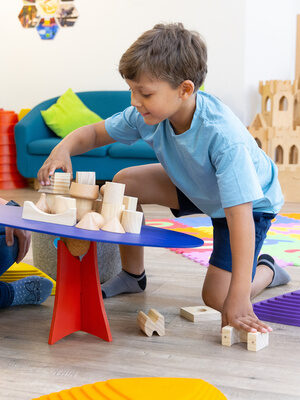 Betreuerin und Kind spielen mit Bauklötzen im Family Club Harz