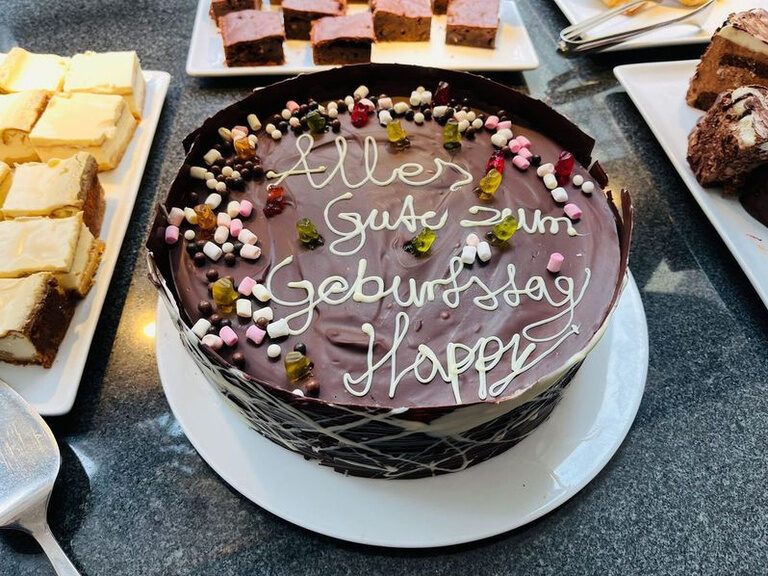 Schokoladentorte mit Geburtstagsgruß und dekorativen Streuseln