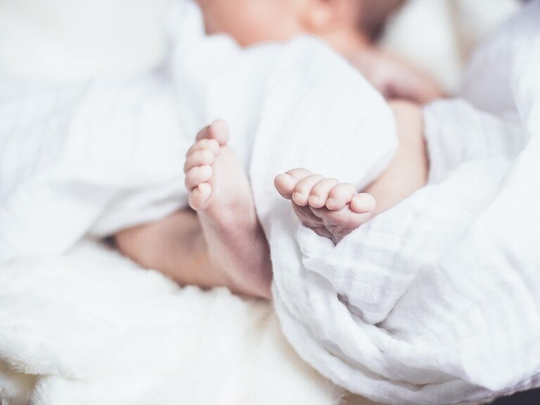 Babyfüße in einer weißen Decke eingehüllt