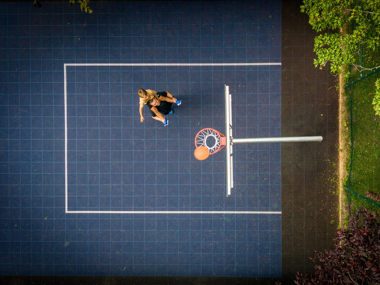 Luftaufnahme von zwei Personen, die Basketball auf einem Basketballplatz spielen