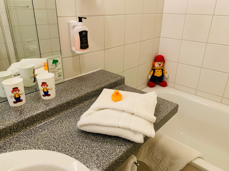 Weiße Handtücher mit Quietschente im Badezimmer