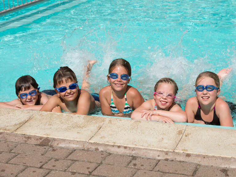 Kinder am Beckenrand im Pool