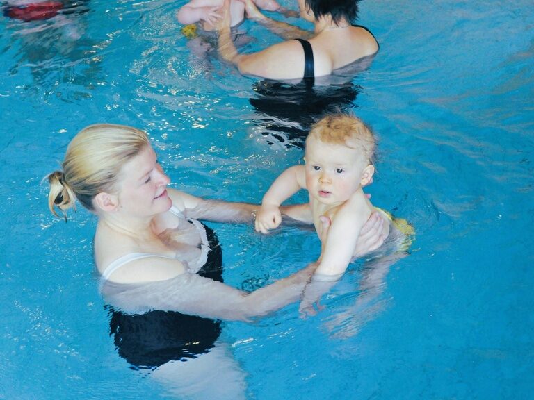 Mutter und Baby beim Babyschwimmen im Schwimmbad