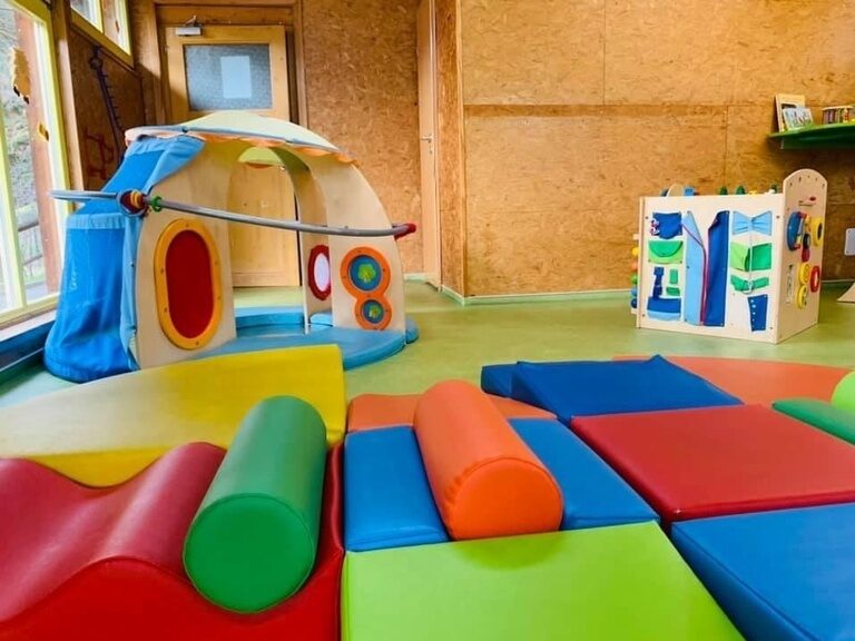 Farbenfroher Softplay Bereich mit weichen Matten für Kinder.